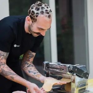 Andrea Lucato rolling pasta through a machine