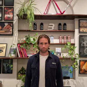 Sam Williams in a bike shop with framed jerseys behind him
