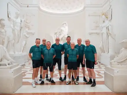 A group in cycling kit among the white sculptures of a gallery