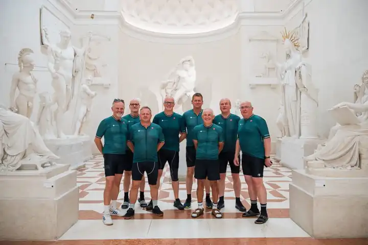 A group in cycling kit among the white sculptures of a gallery