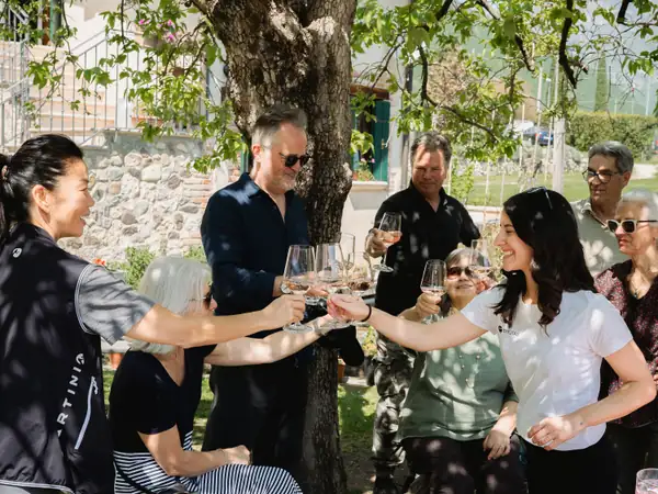 Guests raising glasses around a picnic table, with a dog at their feet