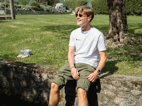 A guest sitting on a low stone wall in a garden