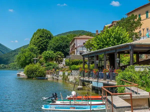 A lakeside restaurant terrace, with small boats moored below