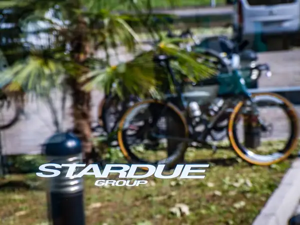 Two bikes parked on a lawn beside a Stardue Group sign