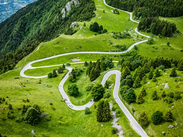 A road of tight hairpins climbing through green meadows