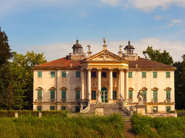 A villa with columns and statues in the evening light