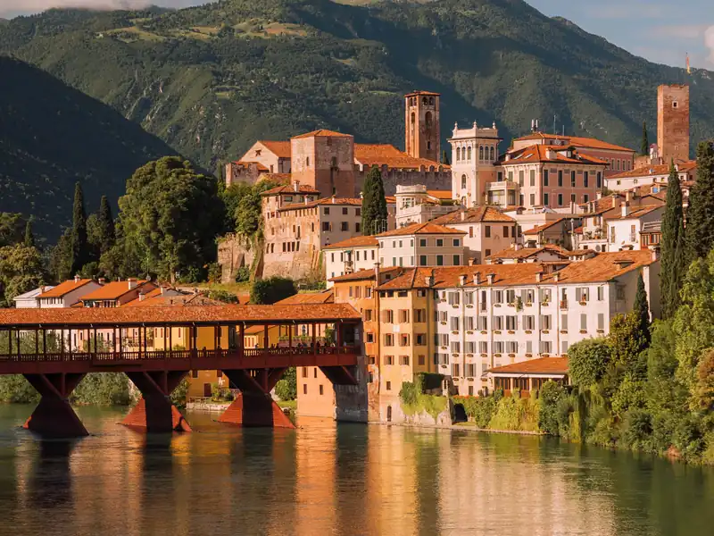 The Ponte degli Alpini and the old town of Bassano del Grappa reflected in the River Brenta at dusk
