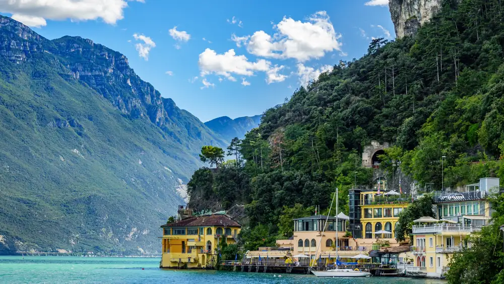 Villas at the water's edge on Lake Garda, below steep wooded cliffs