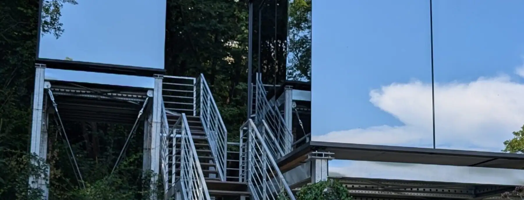 The mirror house at Spino Fiorito, its glass walls reflecting the trees and sky