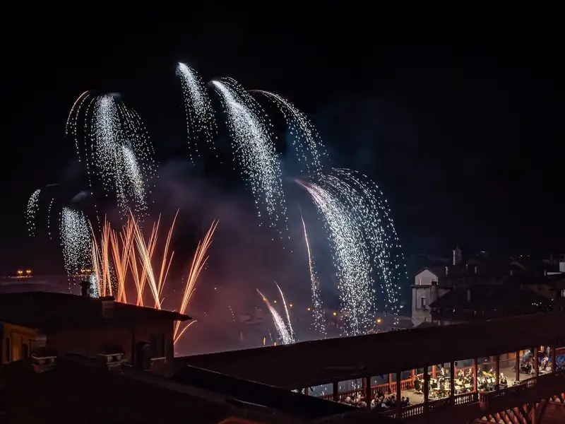 Fireworks over the river and the rooftops of Bassano del Grappa at night